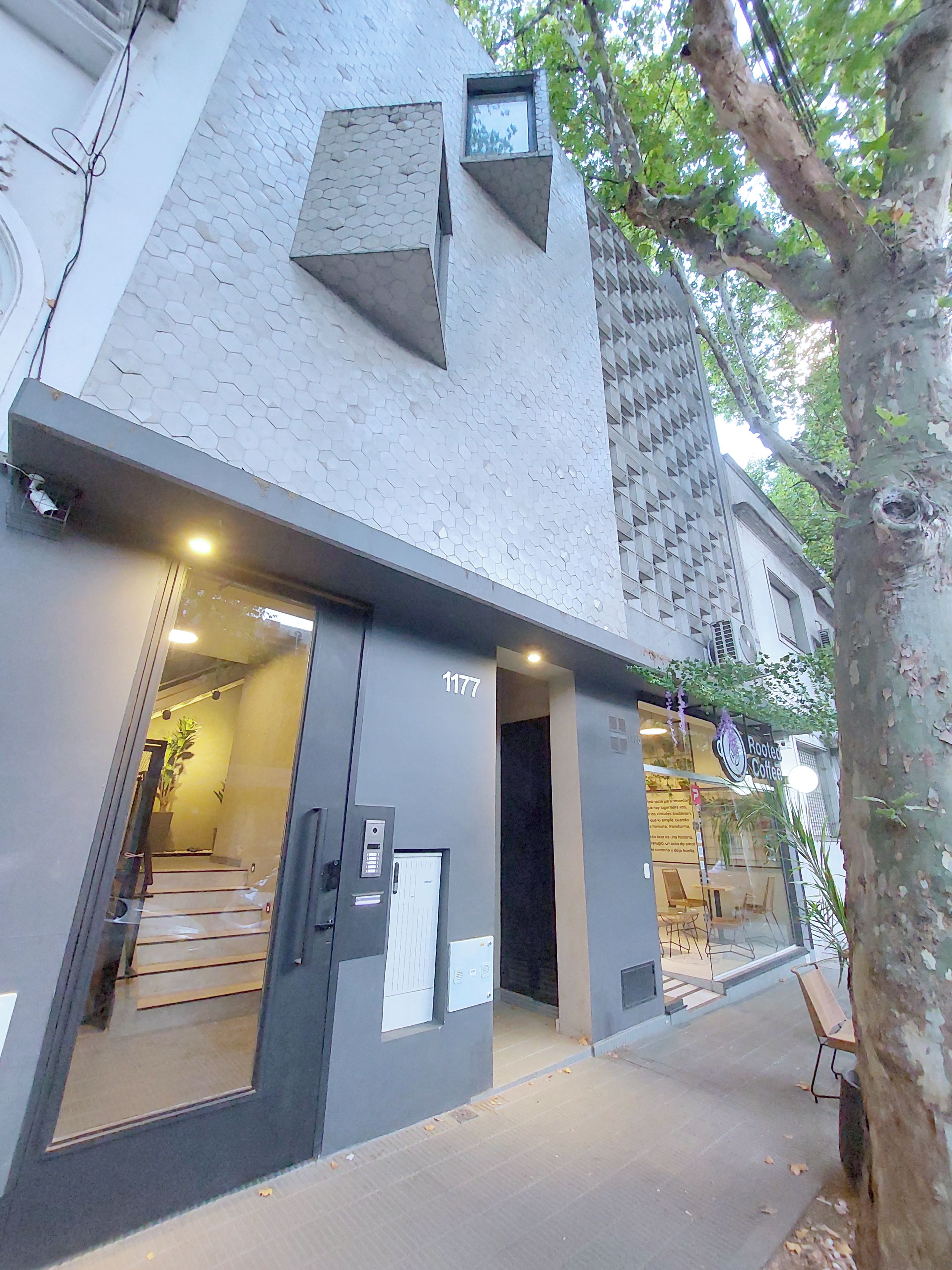 A building with a modern design, featuring a geometric facade and a visible entrance with a staircase.