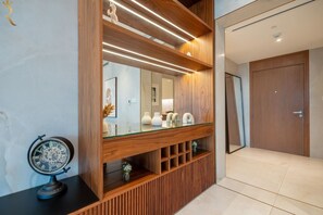 A modern interior with a wooden vanity, a mirror, and a globe on a black surface.