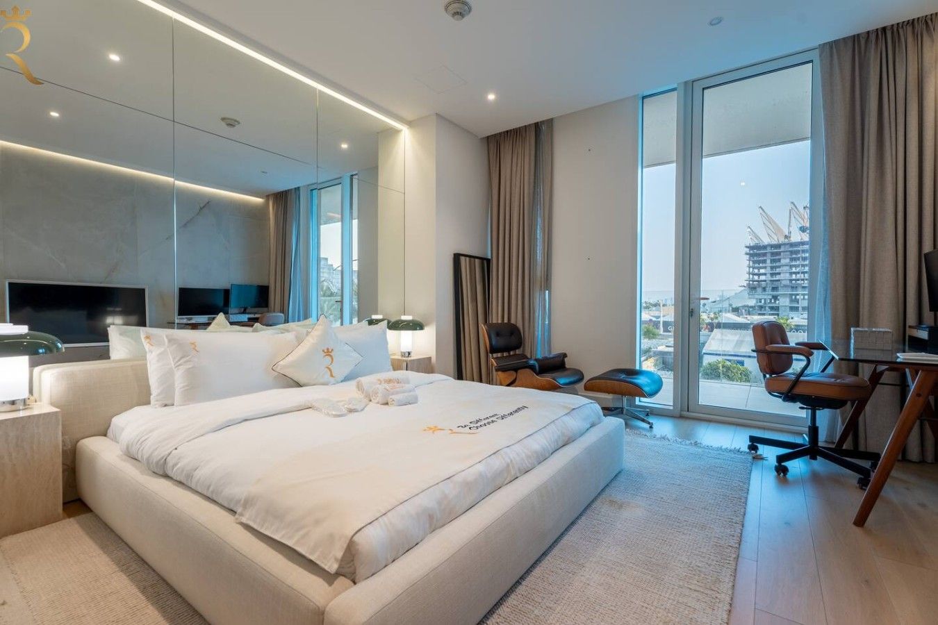Ein modernes Hotelzimmer mit einem großen Bett, einem Schreibtisch und Blick auf die Stadt.