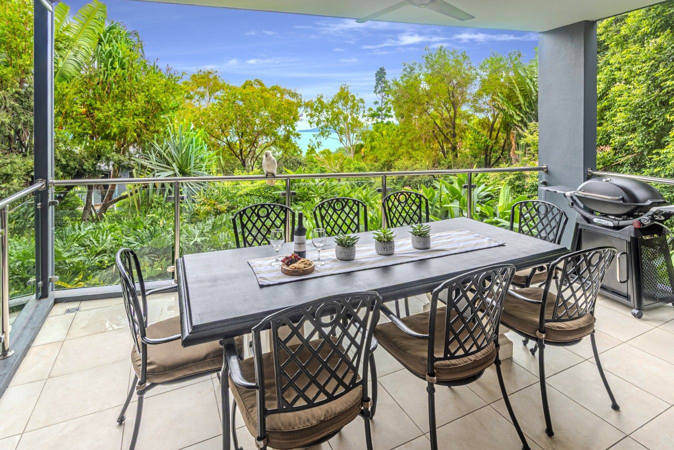 An outdoor dining area with a table, chairs, and a grill.