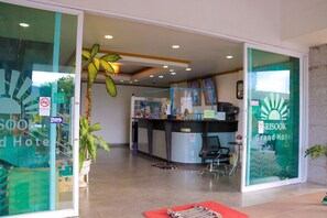 A reception area with a counter, chairs, and a plant.