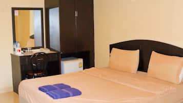 Una camera d'albergo con un letto, una scrivania, una sedia, un armadio e uno specchio.