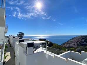 A rooftop terrace with a view of the sea and a hillside town. - Apartment in Malaga With Sea Views & Pool (Nerja)