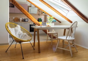 A dining area with a table, chairs, and a yellow chair with a fluffy white cushion. - Cool attic apartment Marina with gallery, in the heart of Split (Split)