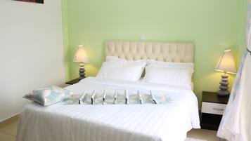 A bed with a tufted headboard, white bedding, and two bedside lamps.