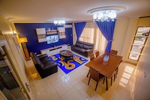 A modern living room with a sofa, a coffee table, and a dining table.