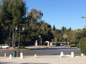 A street intersection with traffic lights, street lamps, and a pedestrian crossing. - Athens Home (Athina)