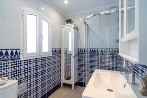 A bathroom with a white sink, a shower, and a toilet. - Apartment in Nerja Near Burriana Beach (Nerja)