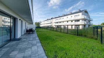 Ein moderner Wohnkomplex mit flachem Dach, großen Fenstern und einem Rasen.