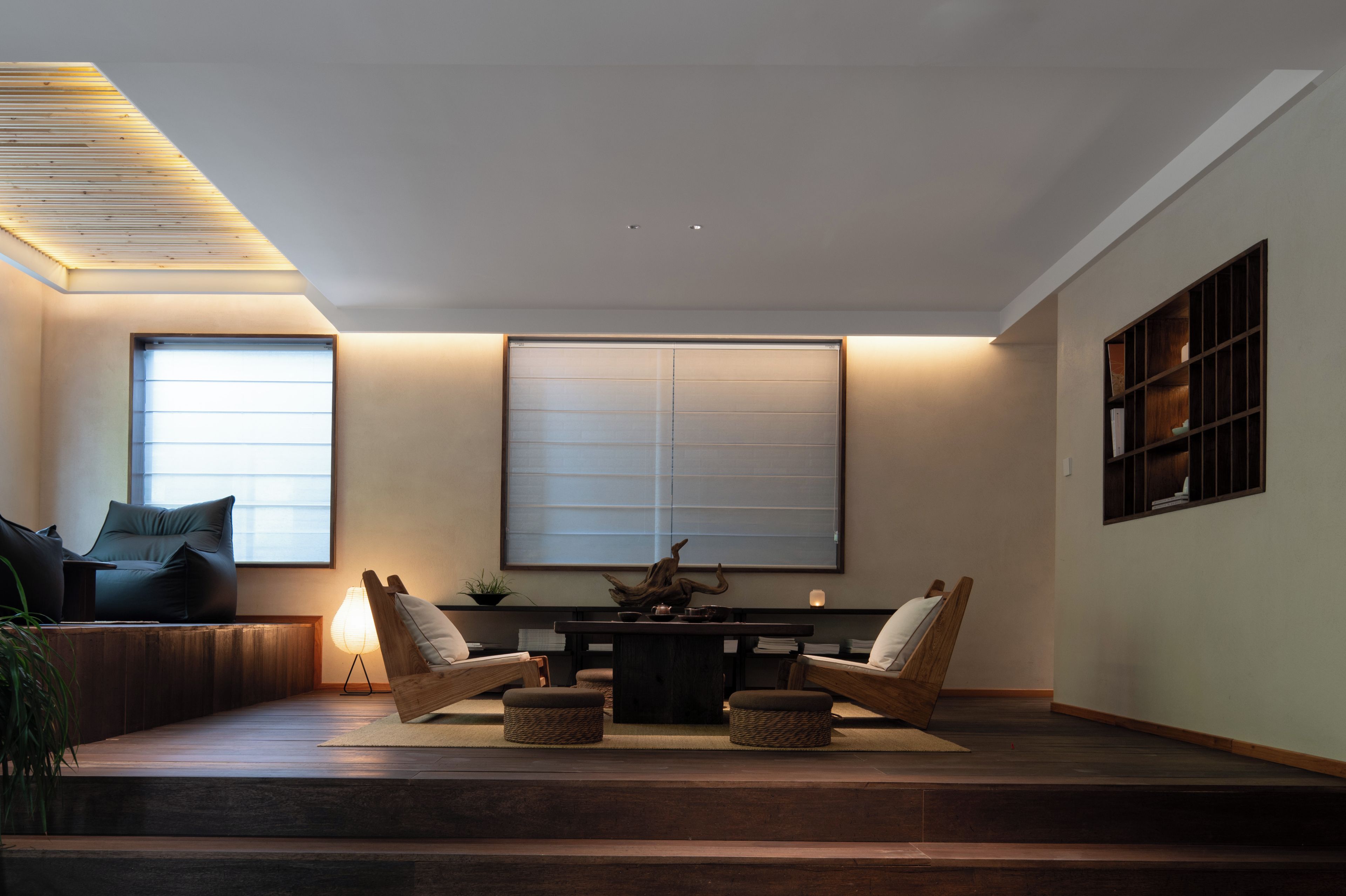 Una sala de estar moderna con un sofá, dos sillones, una mesa y un ventanal grande.