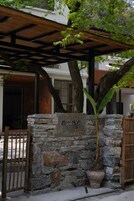 A stone wall with a potted plant and a wooden gate.