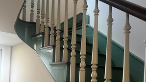 Escadaria com corrimão escuro e balaústres brancos.
