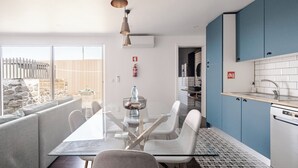 A modern kitchen with blue cabinets, a white countertop, and a stainless steel oven. - Northeast Wind | Basalt Lodge with AC & Jacuzzi and Ocean Views (Lomba da Fazenda)