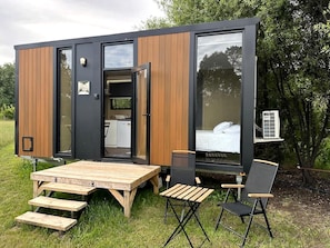 Une résidence mobile moderne et compacte, dotée d’un coin repas, d’un lit et d’une petite kitchenette.