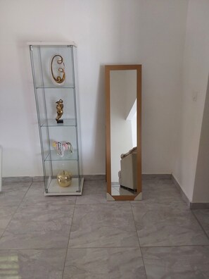A room with a glass display cabinet and a full-length mirror. - Villa Indy (Sainte-Anne)