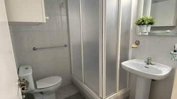 Ein Badezimmer mit Toilette, Bidet, Waschbecken und einer Duschkabine.