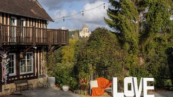 Ein traditionelles Gebäude mit einem Balkon, einem großen Schriftzug 'LOVE' und einer in der Ferne sichtbaren Kathedrale.