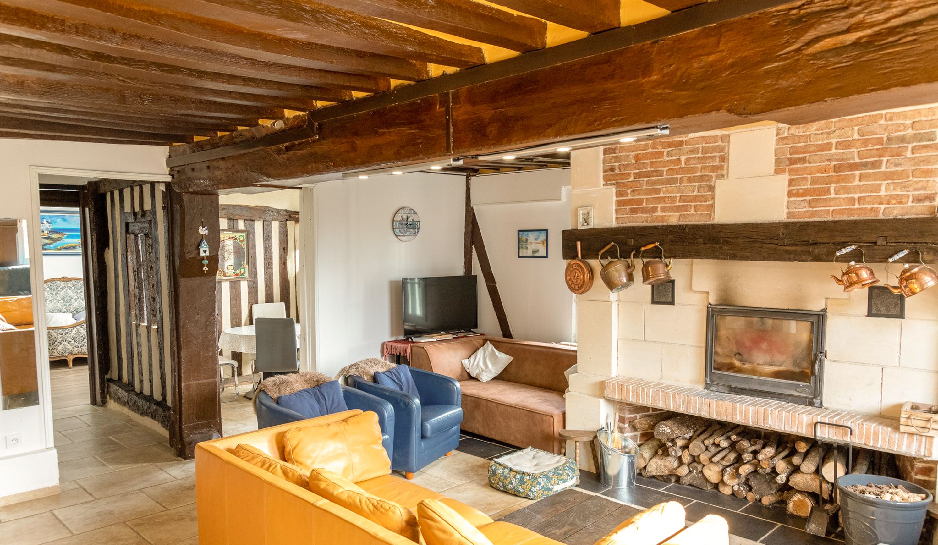 Een gezellige woonkamer met een open haard, een televisie en comfortabele zitplaatsen.
