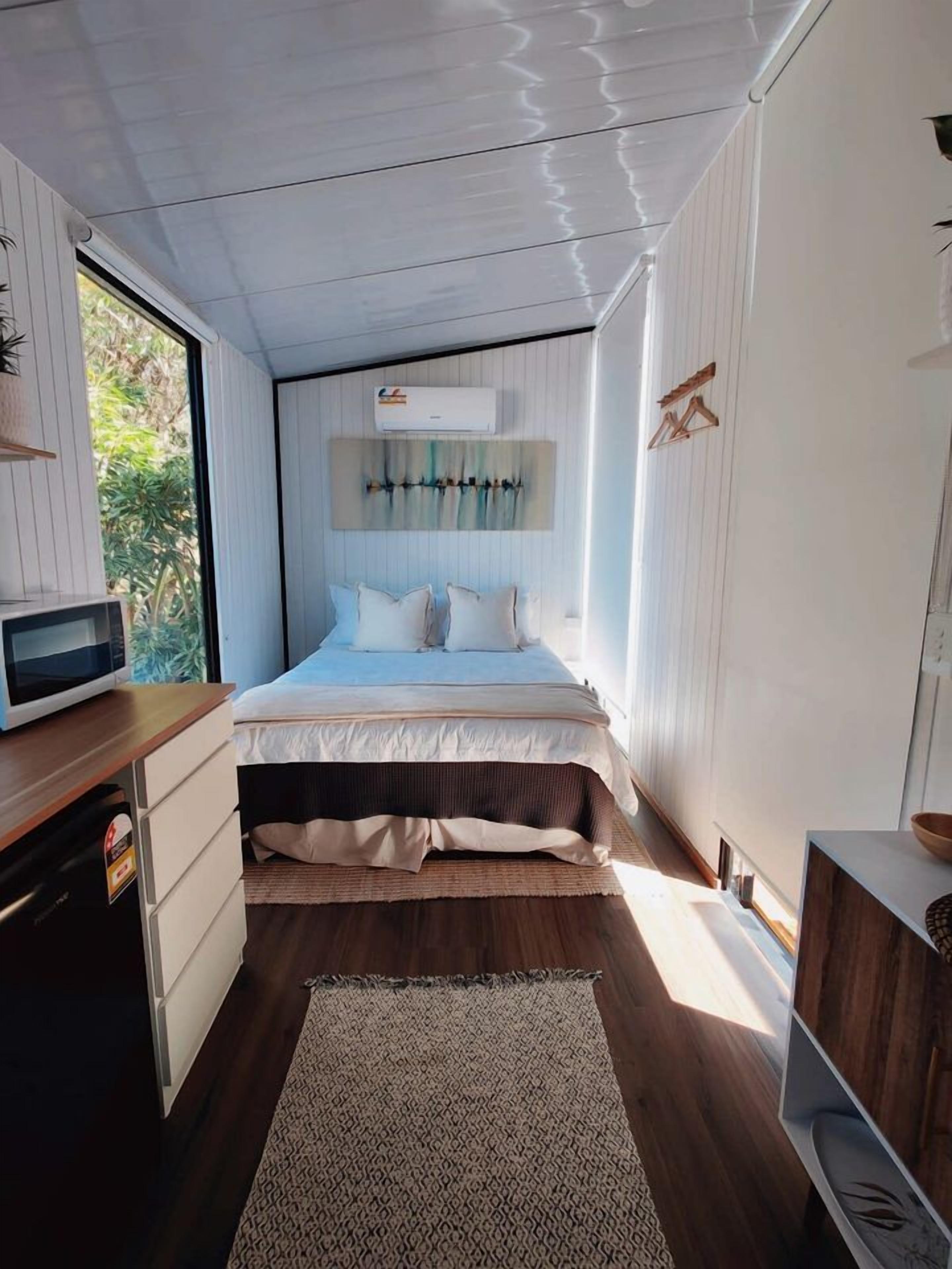 Une chambre avec un lit, une table de chevet, un four à micro-ondes et une fenêtre.