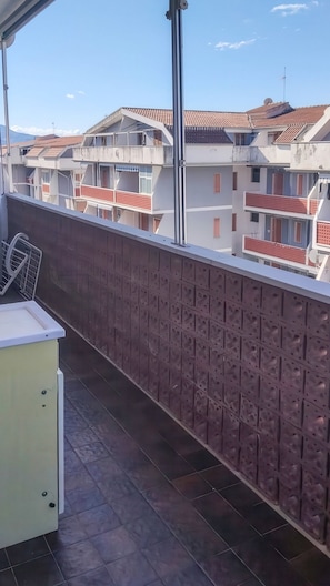 A balcony with a metal railing, a white cabinet, and a tiled floor. - Eden Scalea—Cozy Apartment in a Condominium Complex in Scalea (Scalea)