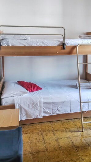 A bunk bed with a wooden frame, white bedding, and a red pillow. - Eden Scalea—Cozy Apartment in a Condominium Complex in Scalea (Scalea)
