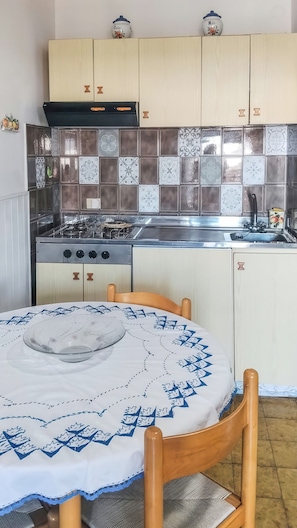 A kitchen with a stove, sink, and cabinets. - Eden Scalea—Cozy Apartment in a Condominium Complex in Scalea (Scalea)
