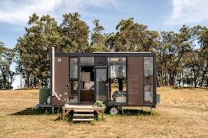 A mobile home with a kitchen area, a dining space, and a sleeping area.
