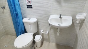 A bathroom with a toilet, sink, and a blue shower curtain. - Your ideal getaway: an apartment 5 m from Honda (Puerto Bogotá, Guaduas)
