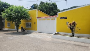 A yellow building with a white door, a satellite dish, and a sign indicating 'Villa del Sol Calle 3 #2-45'. - Your ideal getaway: an apartment 5 m from Honda (Puerto Bogotá, Guaduas)