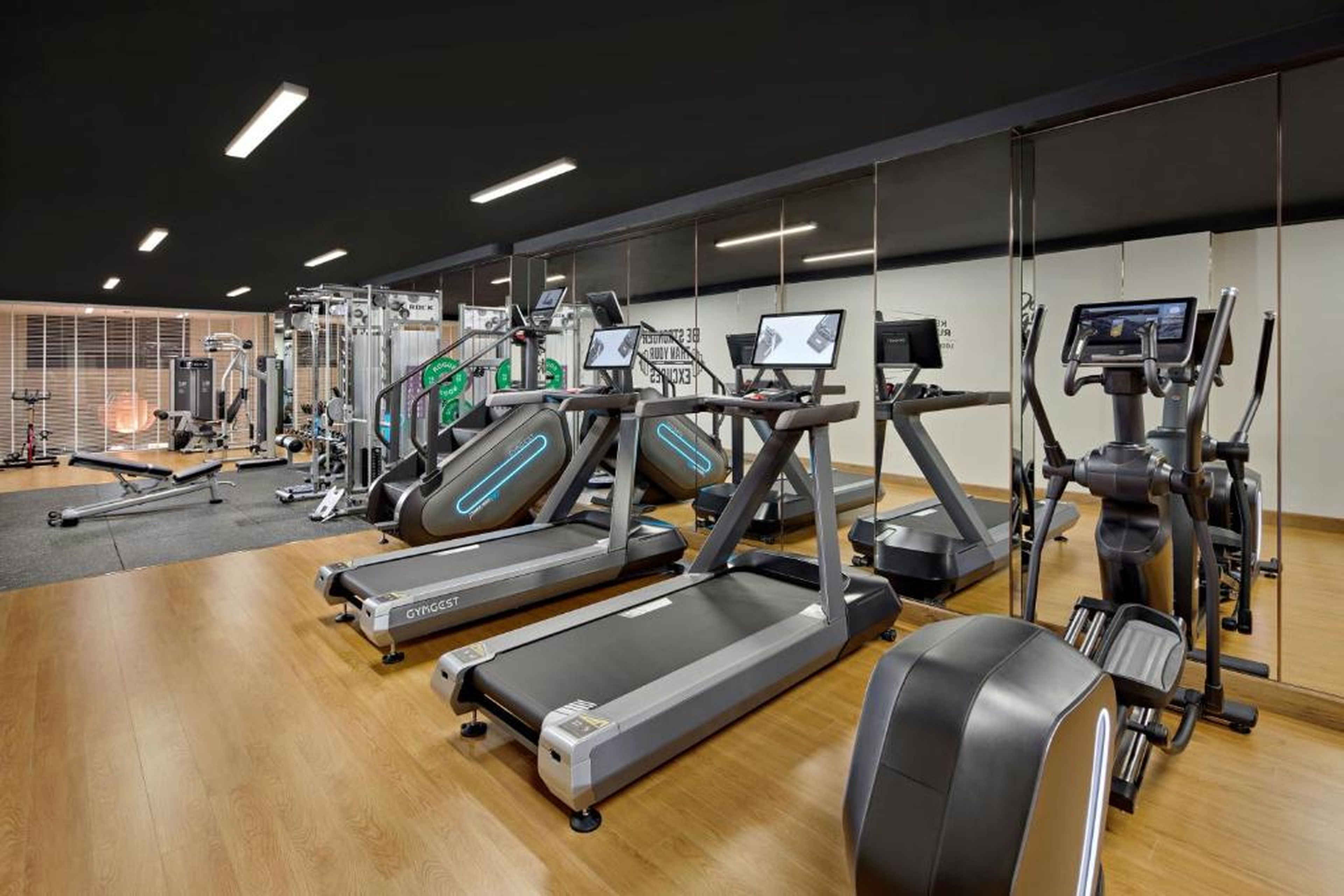A gym with treadmills, ellipticals, and weight machines.