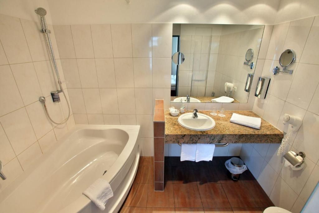Ein modernes Badezimmer mit einer Badewanne, einem Waschbecken und einer Dusche.