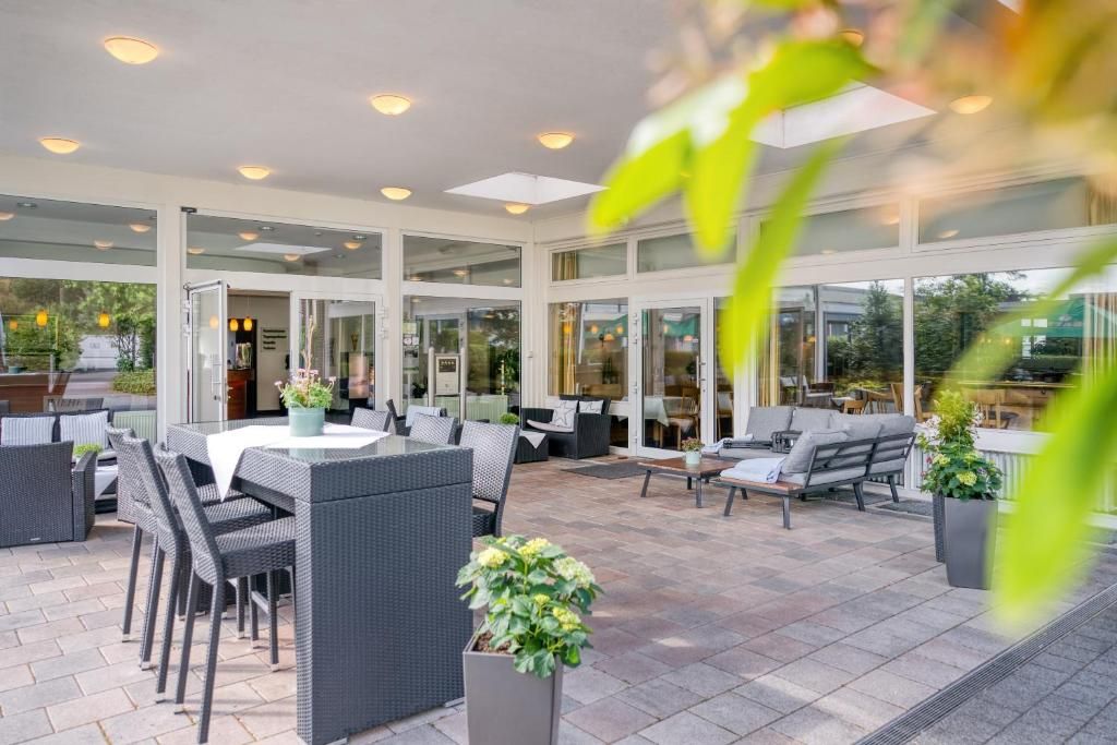 Un patio al aire libre con una mesa de comedor, sillas y sofás.