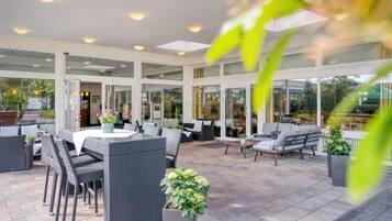 An outdoor patio area with a dining table, chairs, and sofas.