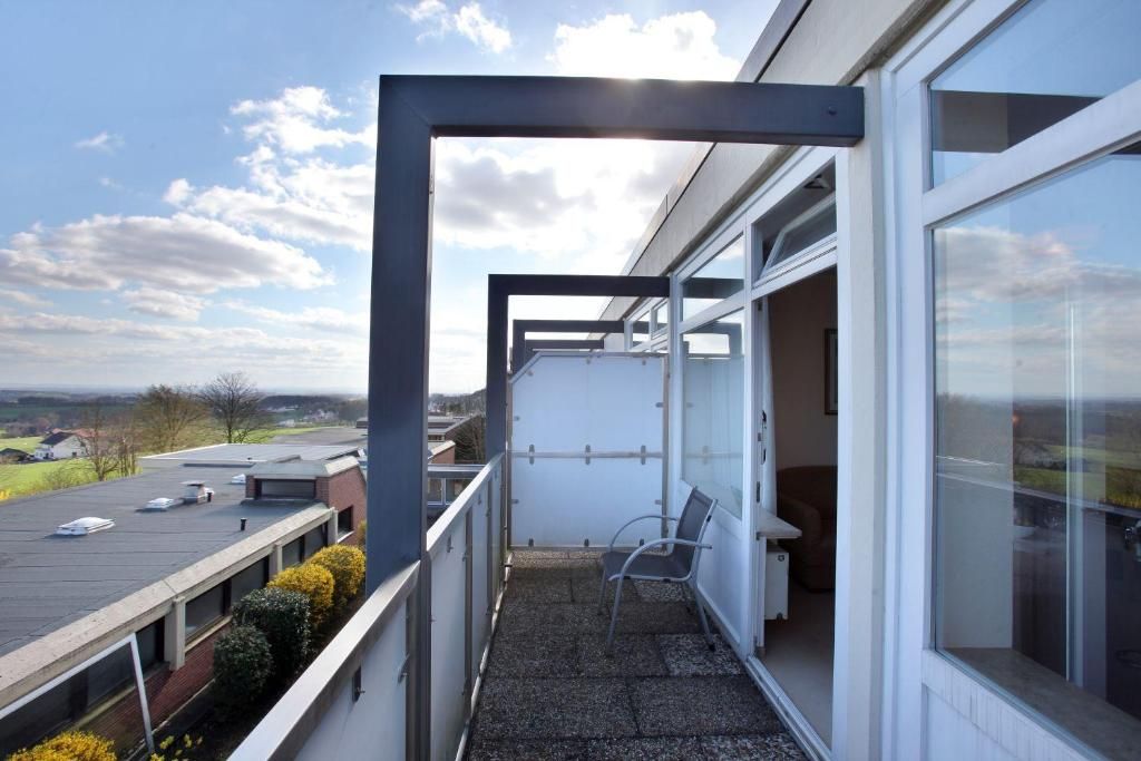 Ein Balkon mit Blick auf die Landschaft, ein Stuhl und ein Tisch.