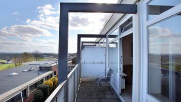 Ein Balkon mit Blick auf die Landschaft, ein Stuhl und ein Tisch.