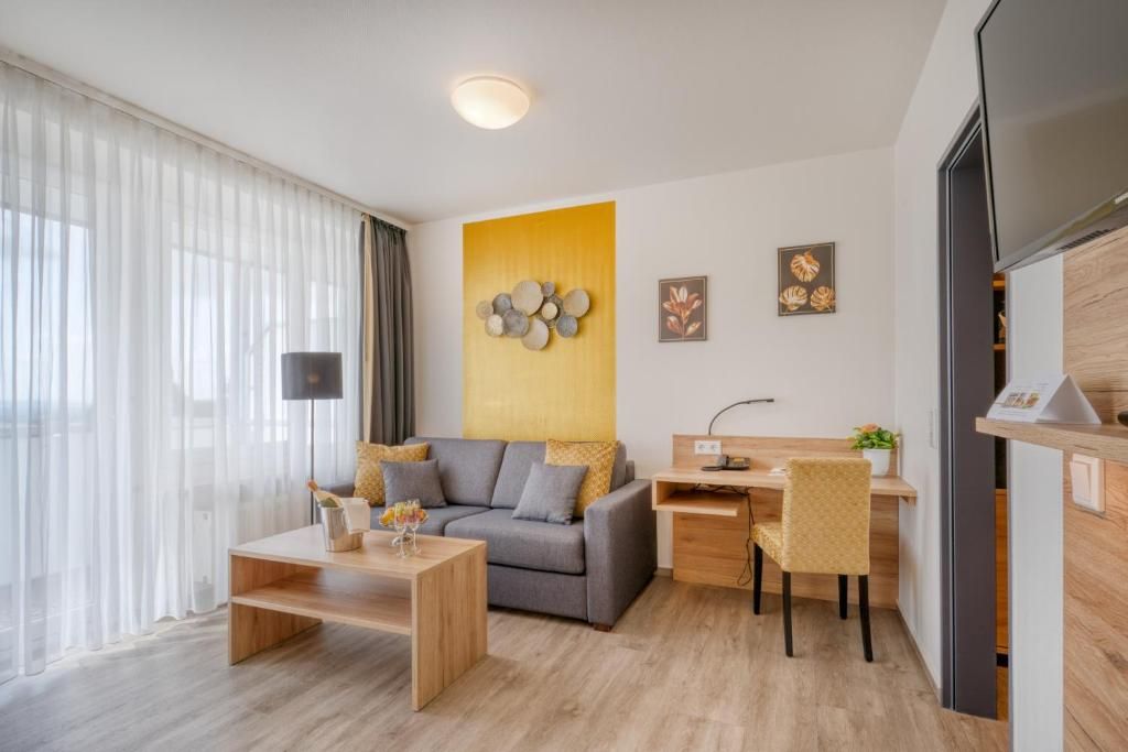 Un salon moderne comprenant un canapé, une table basse et un bureau avec une chaise.