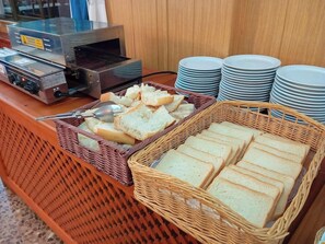Montaje de bufé con pan, platos y un tostador.