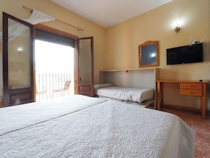 Una habitación de hotel con dos camas, un televisor, un escritorio y una silla.