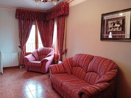 Una habitación con dos sofás, un radiador y un cuadro en la pared.