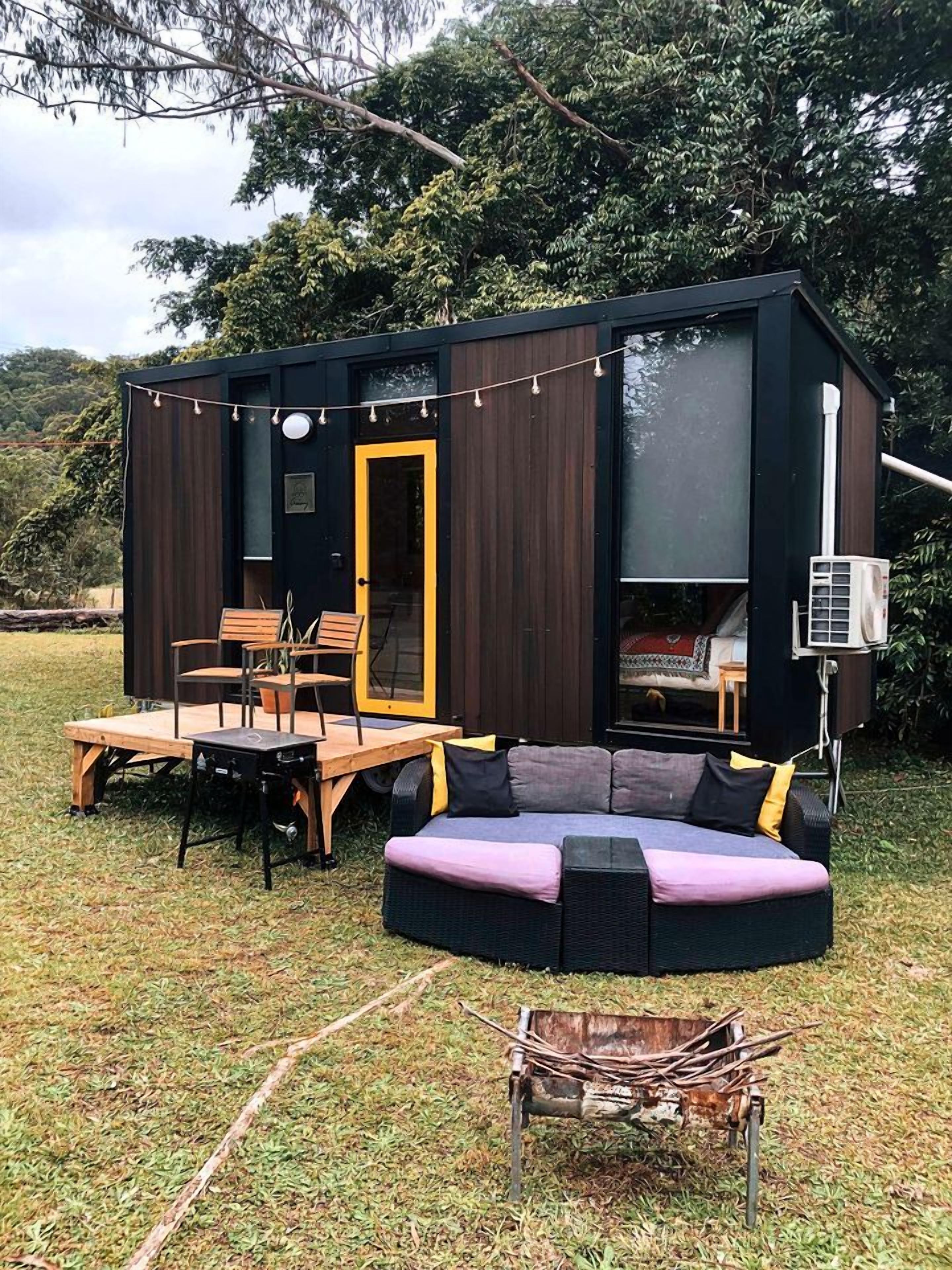Un espace de vie extérieur moderne, doté d’un coin salon intégré, d’une table et de chaises.