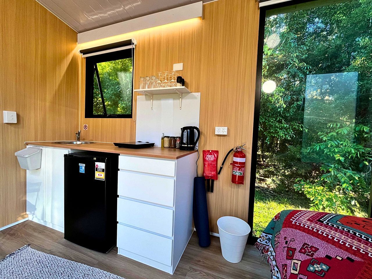Una kitchenette funcional con refrigerador, estufa y pileta.