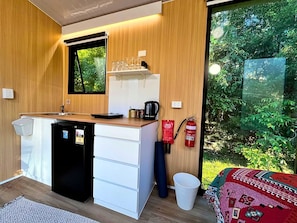 Eine kleine Küchenzeile mit Kühlschrank, Herd und Spüle.
