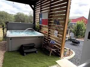 Een jacuzzi met een houten terras en een Texas vlag.