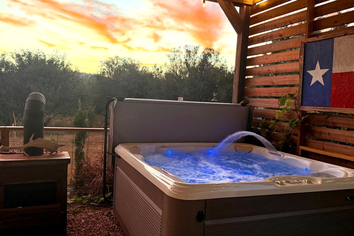 A hot tub with a wooden deck and a Texas flag.