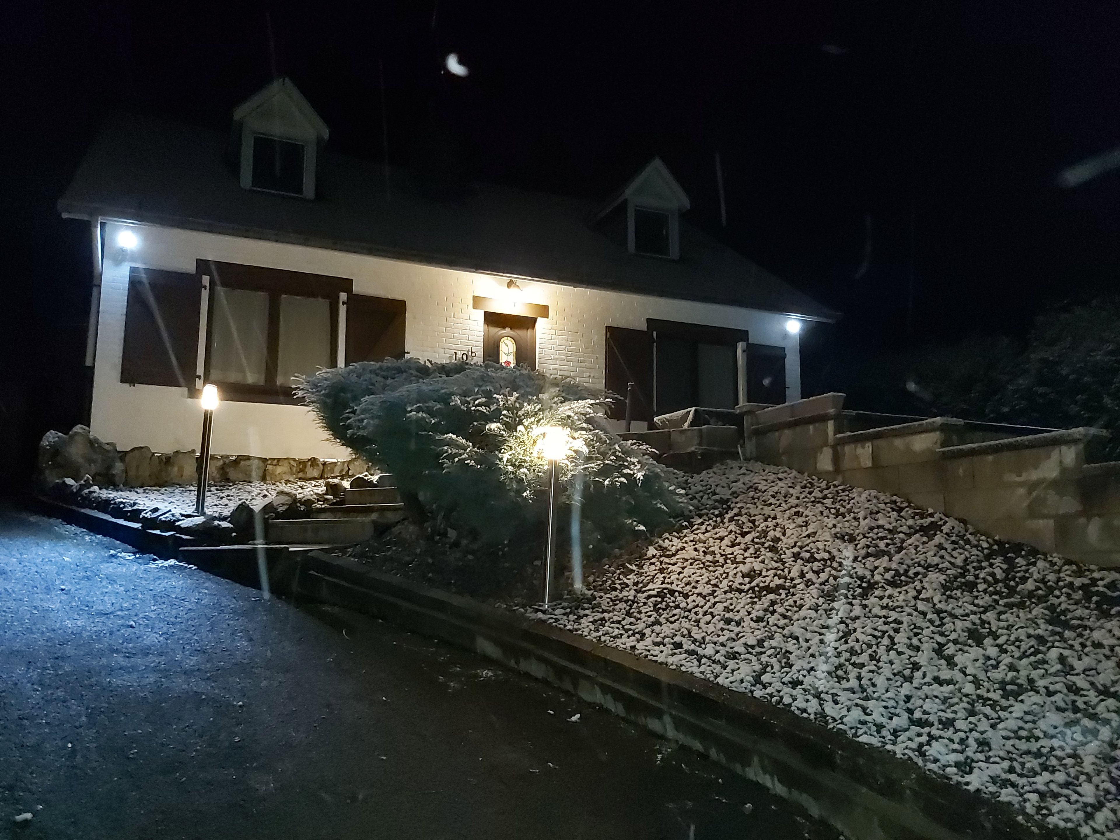 A house with a sloped roof, a small porch, and a snow-covered ground.