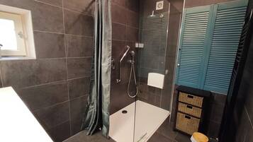 A bathroom with a shower, a toilet, and a sink.
