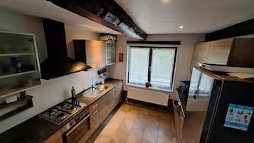 Een moderne keuken met een gasfornuis, spoelbak en een raam met uitzicht.