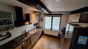 Una cuina moderna amb fogó de gas, rentaplat i finestra amb vistes.