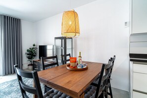 A dining area with a wooden table, black chairs, a hanging light fixture, and a potted plant. - Holiday Home in Nerja With Sea Views (Nerja)