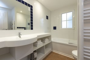 A modern bathroom with a large white sink, a mirror, a bathtub, and a toilet. - Les Greens Du Bassin (Gujan-Mestras)